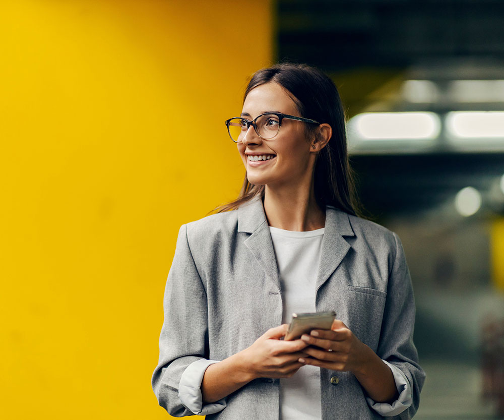 Woman smiling in front of a yellow wall