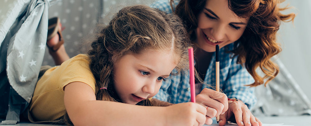 Woman and girl coloring on the floor