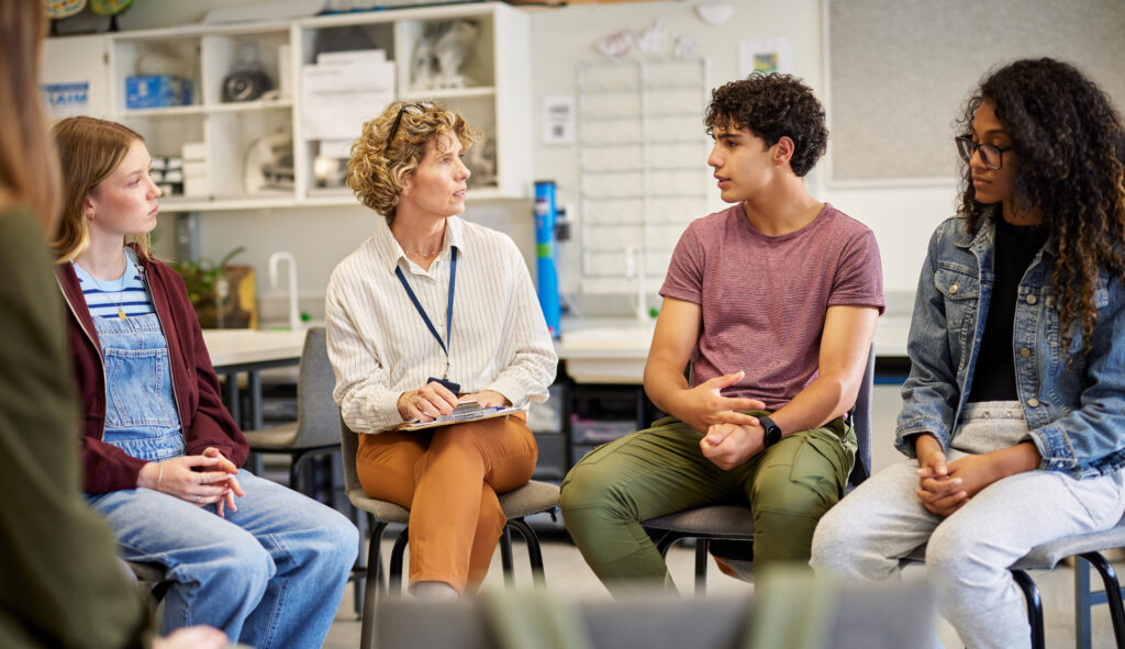 A group of teenagers in a discussion circle with a therapist